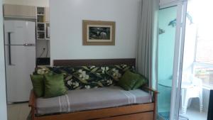 uma sala de estar com um sofá com almofadas verdes em Lindo Apto, 50metros do mar, Ideal Para Familias em Florianópolis