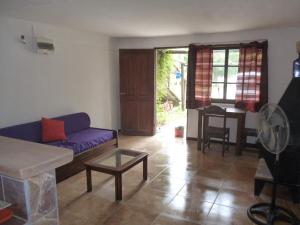 a living room with a purple couch and a table at PORTOFINO BARRIO COUNTRY in Piriápolis