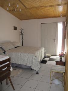 1 dormitorio con cama, ventana y puerta en Cabañas Lemupewen Chillán 1 en Chillán