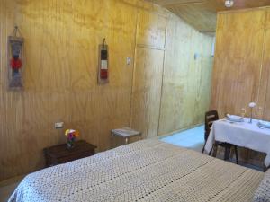 1 dormitorio con cama, mesa y mesa en Cabañas Lemupewen Chillán 1, en Chillán