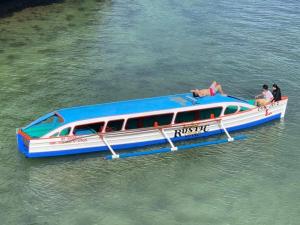 a blue and white boat in the water at Rustic Crown Hotel in Alaminos