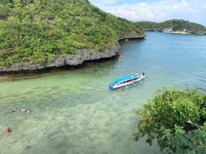a boat in the water next to a small island at Rustic Crown Hotel in Alaminos
