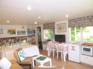 a kitchen and living room with a table and chairs at Aimeo Cottage in Russell