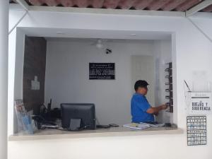 HOTEL PARAISO ACAPULCO في أكابولكو: رجل يقف عند مكتب