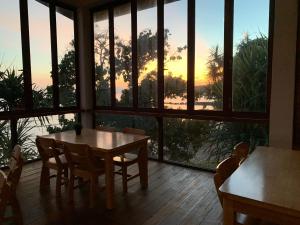 a room with a table and chairs and a large window at Pulau Weh Paradise in Sabong