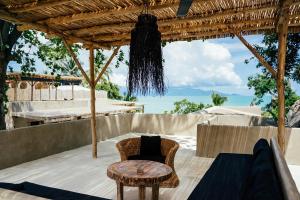 a patio with a table and a chair and a bed at Karma Resort in Bophut