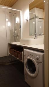 a bathroom with a washing machine and a sink at Tahko Chalet B 601 in Tahkovuori