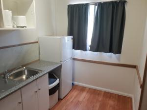 a small kitchen with a sink and a refrigerator at Big4 Acclaim Prospector Holiday Park in Kalgoorlie
