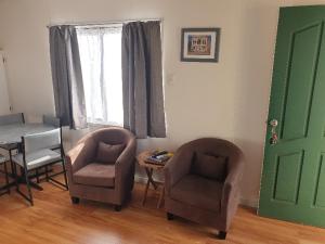 a living room with two chairs and a table and a window at Big4 Acclaim Prospector Holiday Park in Kalgoorlie