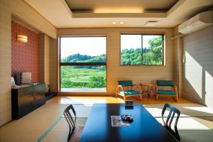 Habitación con mesa, sillas y ventana grande. en Shizukatei, en Hiraizumi