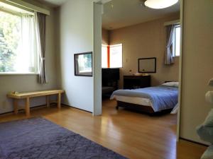um quarto com uma cama, uma mesa e um espelho em ペンション ラリー em Kawazu