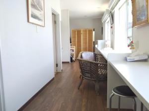 a kitchen with a counter and a chair in a room at ペンション ラリー in Kawazu