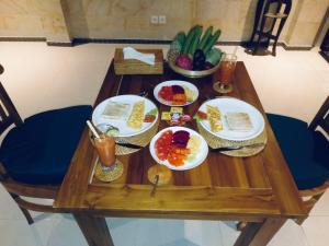 Sari House Ubud في أوبود: طاولة خشبية عليها صحون طعام