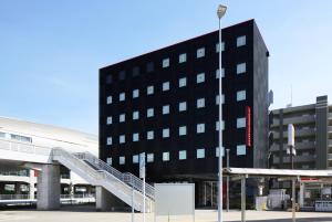 un edificio negro con una escalera delante en SAKURA SKY HOTEL KASHIWA(桜スカイホテル柏), en Kashiwa