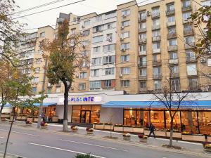 un bâtiment dans une rue de la ville avec un magasin dans l'établissement Central Park Apartment on Pushkin 33, à Chişinău