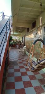 a porch with chairs and a checkered floor at Manasa guest House in Hampi