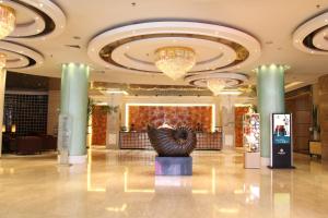 a lobby with a sculpture in the middle of a building at The Center Hotel Weihai in Weihai