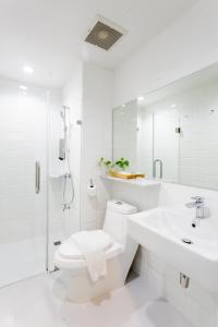 Baño blanco con aseo y lavamanos en The Core Street By Stay Now - SHA Plus en Chiang Mai