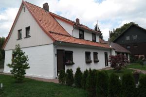 a white house with an orange roof at Ferienwohnung Haus Zeier in Hahnenklee-Bockswiese