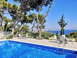 a swimming pool with chairs and a view of the ocean at Louis Luxury Villa by living in blue in Rhodes Town