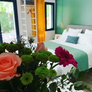 a bedroom with a bed and a bouquet of flowers at "Une Pause au Vert" Studio 2 personnes in Châteauvieux