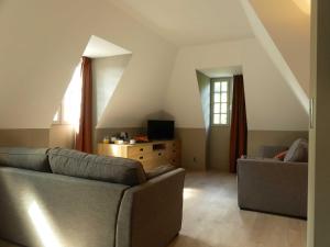 a living room with two couches and a tv at LE CASTEL D'ALTI in Luchon