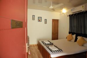 Habitación con cama y puerta roja en Baywatch Beach Resort, en Alleppey