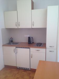 a kitchen with white cabinets and a sink at Pension Weber in Tamsweg