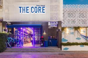 a store front with a purple sign on the door at The Core Street By Stay Now - SHA Plus in Chiang Mai