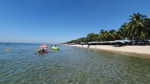 uma praia com pessoas e barcos na água em The Patio Bangsaen em Bangsaen