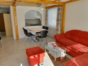 a living room with a red couch and a table at Haus Apollo in Saas-Almagell