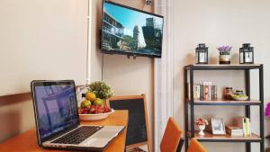 ordenador portátil con mesa y TV en Baan U-Sabai บ้านอยู่สบาย, en Bangkok