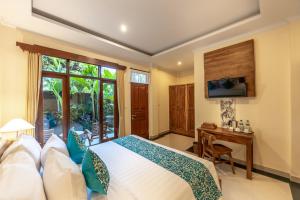 a bedroom with a bed and a desk and a television at Juwuk Manis in Ubud +25 photos