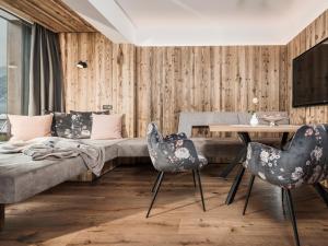 - un salon avec un canapé, une table et des chaises dans l'établissement Platzhirsch Apart & Mayrhofen, à Mayrhofen