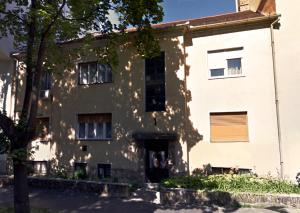 budynek z drzewem przed nim w obiekcie Margaréta Apartman w mieście Pecz