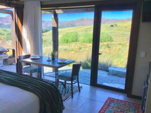 a bedroom with a bed and a table with a view at HawkRidge Alpine Suite in Queenstown