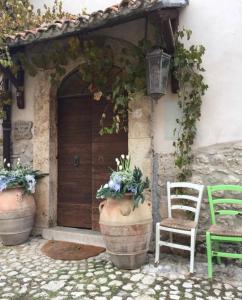 ein Haus mit zwei großen Töpfen und einer Tür in der Unterkunft Tenuta di Vico Moricino in Anagni