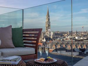 布魯塞爾的住宿－Sweet Inn - Saint Jean，阳台配有沙发和带酒杯的桌子。