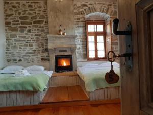 a bedroom with two beds and a fireplace at Lichovo in Papingo