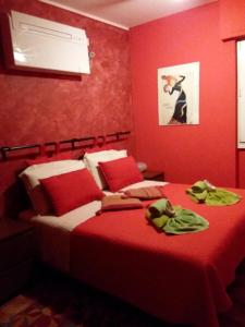 a bedroom with red walls and a bed with towels on it at Orange House in Varenna
