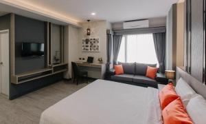a hotel room with a bed and a desk at Arista Hotel Ubon in Ubon Ratchathani