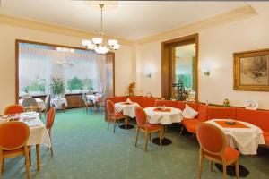 ein Restaurant mit Tischen und Stühlen und einem großen Fenster in der Unterkunft Hotel Fidelitas in Bad Herrenalb