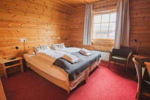 1 dormitorio con 1 cama en una habitación de madera en Hotel Framtid, en Djúpivogur