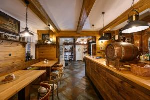 a large room with wooden walls and a bar with tables at MAXMILLIAN Pension & Restaurant in Mařenice