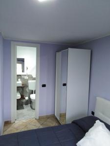 エルコラーノにあるLa Mariposa de La Reinaのベッドルーム1室(ベッド1台付)、バスルーム(トイレ付)