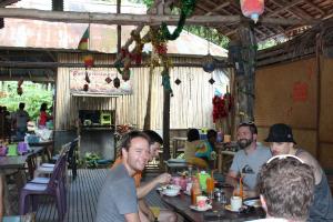 een groep mensen die aan een tafel in een restaurant zitten bij Chill Out Bar and Jungle Bungalows in Krabi town