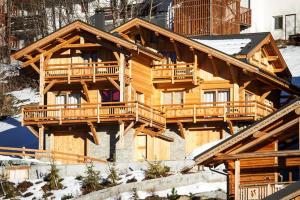 a log cabin in the snow with decks at Chalet l'ALPAGA 2 in Les Deux Alpes