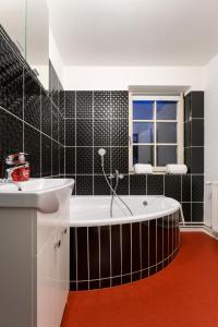 bagno con vasca, lavandino e finestra di MAXMILLIAN Pension & Restaurant a Mařenice