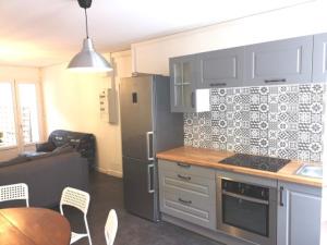 a kitchen with a refrigerator and a table and chairs at A bon port in Mareuil-le-Port