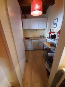 a kitchen with white cabinets and a red light at Kellerstöckl Kamper in Eisenberg an der Pinka